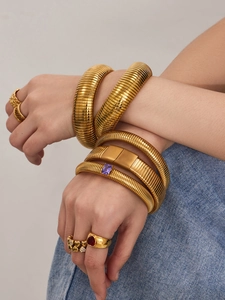 Détail du bracelet manchette plaqué or 18k et bagues en zircon portés avec denim