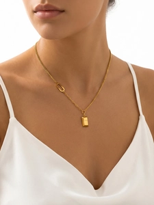 Close-up of 18k gold plated stainless steel bar necklace with LOVE engraving on model
