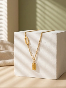 Detail of 18k gold plated necklace with LOVE bar pendant and asymmetric chain link