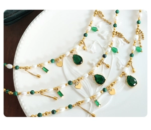 Detail of bohemian necklace with freshwater pearls, green malachite beads and heart charms