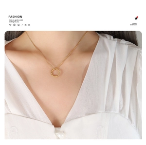 Elegant gold twisted ring pendant necklace shown worn on a model with minimalist style