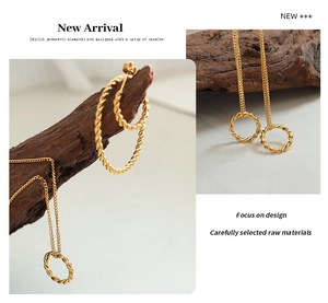 Close-up of golden twist rope hoop earrings and matching circle pendant necklace on wood