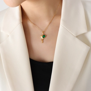Lava drip gold heart necklace with dark green gemstone pendant on model