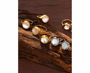 Macro-opname van goud- en zilverringen met schelpinleg op getextureerd hout