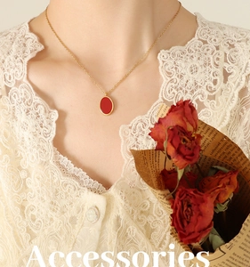 Close-up of French vintage gold chain necklace with an oval red pendant on model