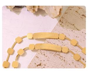 Macro shot of gold snake chain bracelet featuring engraved Love without end message