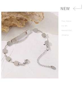 Macro view of silver stainless steel bracelet with engraved inspirational message and K18 tag