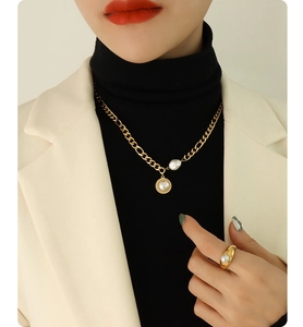 Detail of 18k gold chain necklace with freshwater pearls and matching ring on a model