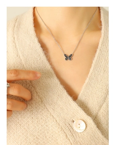 Détail du collier pendentif papillon bohème avec émail noir et blanc sur le modèle