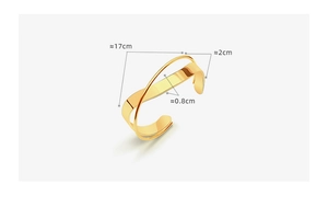 Close-up of minimalist crossover gold cuff bracelet with detailed size measurements