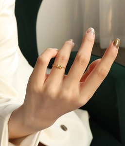 Gros plan d'une bague chaîne minimaliste plaquée or 18 carats à deux perles