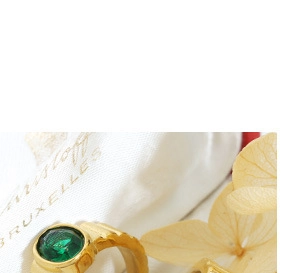 Dettaglio anello vintage dorato con gemma verde e trama a scanalature verticali