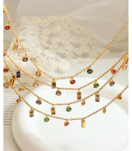 Dettaglio della collana dorata con pendenti di gemme colorate multi-forma