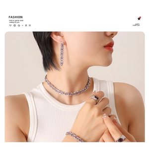 Close-up of silver jewelry set featuring purple rectangular stones and link chain design