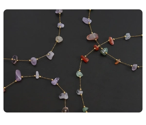 Dettaglio della collana con pietre naturali irregolari con perline dorate e catena sottile