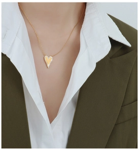 Nahaufnahme der Herz-Halskette mit Zirkonia-Inlay an einem Model im grünen Blazer