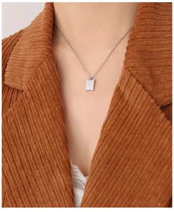 Dettaglio della collana con pendente Good Luck su modella con sfondo lifestyle