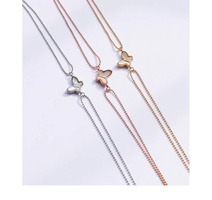Detailed macro of butterfly pendants in silver, gold, and rose gold with mop inlays