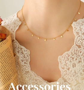 Détail d'un collier en titane doré avec de petits pendentifs triangles porté par un mannequin
