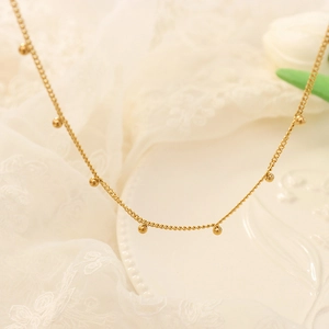 Collar minimalista de cuentas doradas para mujer con pequeños colgantes redondos y cadena