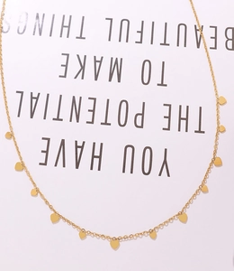 Vue rapprochée d'un collier en chaîne d'or 18K avec plusieurs petits pendentifs cœur