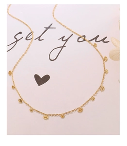 Détail d'un collier plaqué or 18 carats avec de petits pendentifs en forme d'œil ciselé
