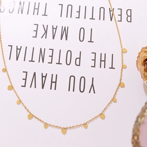 Minimalist gold heart charm necklace on elegant decorative background paper