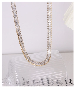 Detailweergave van een vergulde tennis ketting met emerald geslepen zirkonia steentjes