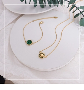 Detail of eight-pointed star pendant and bracelet set with green malachite stone inlay