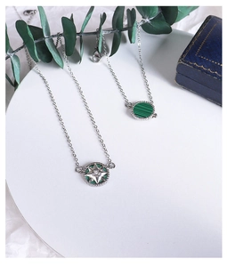 Detail of double-sided star compass necklace with green malachite in silver finish