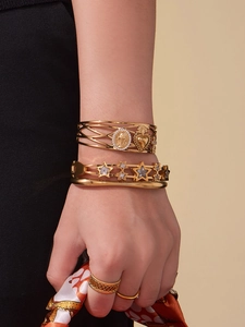 Détail de bracelets étoiles et bagues en acier plaqué or 18k avec zircons 5A brillants