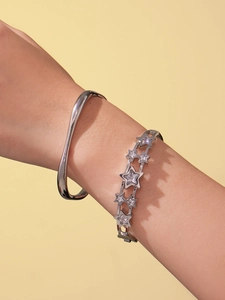 Gros plan sur un bracelet vague en argent et jonc étoile en zircon 5A avec ombres