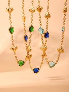 Detail of gold-plated heart necklace featuring colorful glass stones and sleek metallic charms