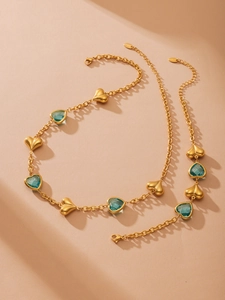 Detail of gold necklace with transparent blue heart stones and lobster clasp closure