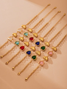 Detailed macro view of heart-shaped glass stone bracelets in six vibrant colors with gold plating
