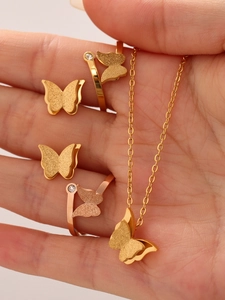 Macro-opname van vlinder sieradenset in 18k goud met details van matte textuur