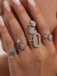 Dettagli di anelli in argento con motivi a cuore e tartaruga e zirconi brillanti
