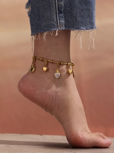 Primer plano de la pulsera de trébol dorada con colgantes de corazón de circonio