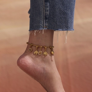 Pulsera de trébol en acero dorado con dijes de corazón y circonitas brillantes