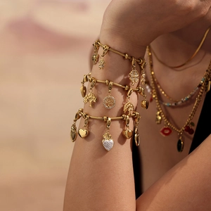 Conjunto de pulsera y collar multicapa de acero dorado con dijes de trébol y circonita