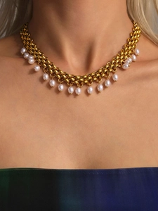 Vue détaillée du collier à grosse chaîne dorée avec pampilles en perles blanches