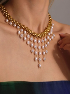Vue détaillée d'un collier à chaînes dorées avec des pampilles de perles blanches