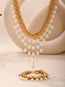 Détail du collier à franges dorées avec perles blanches et grosse chaîne en acier robuste
