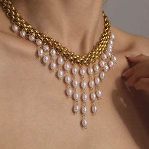 Collier chaîne dorée avec glands de perles multicouches porté par un mannequin en gros plan