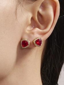Close-up of red heart zircon earrings with gold plating and crystals on a model