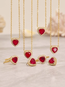 Macro shot of a luxury jewelry set with red heart zircon pendants and sparkling diamonds