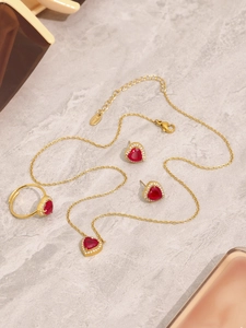 Macro shot of red heart zircon jewelry set with necklace earrings and open ring details