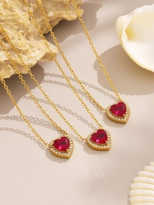 Detailed macro view of heart-shaped red zircon pendant necklaces with gold finish