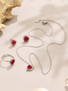 Detail of red heart zircon jewelry set with necklace, earrings and ring in stainless steel