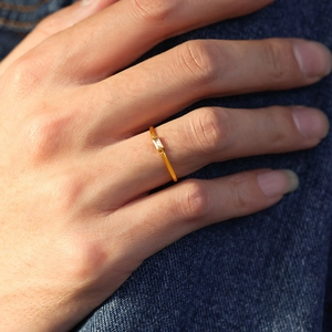 Minimalist double-layer gold plated ring with baguette-cut zircon worn on finger